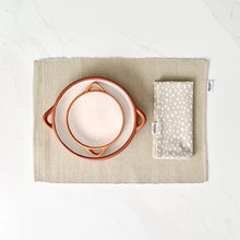 Load image into Gallery viewer, Two glazed terracotta tapas dishes in cream and orange colors, displayed on a matching cotton placemat with a white and cream patterned napkin to the side.