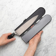 Load image into Gallery viewer, Knife with a sheath held by hands on a light gray surface