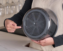 Load image into Gallery viewer, A person holding a gray Zyliss salad spinner with a transparent bowl and a black pump mechanism.