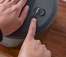 Load image into Gallery viewer, Person pressing a button on a salad spinner on a wooden surface