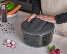 Load image into Gallery viewer, Person using a salad spinner with vegetables on a kitchen counter