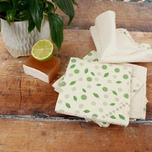 Load image into Gallery viewer, Folded cloth napkins with green patterns on a wooden surface with a lime and soap.