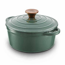 Load image into Gallery viewer, A green cast iron casserole dish with lid and two handles on a kitchen counter.
