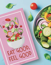 Load image into Gallery viewer, a salad themed book next to a bowl of dsalad on a blue background with green leaves and a tomato
