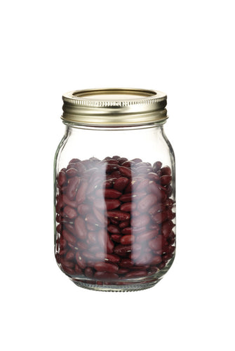 Glass jar with a gold lid filled with red beans on a white background
