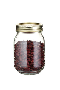 Glass jar with a gold lid filled with red beans on a white background