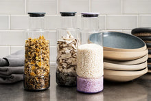 Load image into Gallery viewer, Three glass jars with different contents on a kitchen counter.
