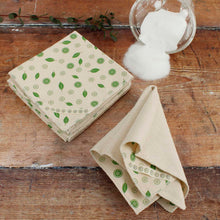 Load image into Gallery viewer, Folded cloth napkins with green leaf pattern on a wooden surface
